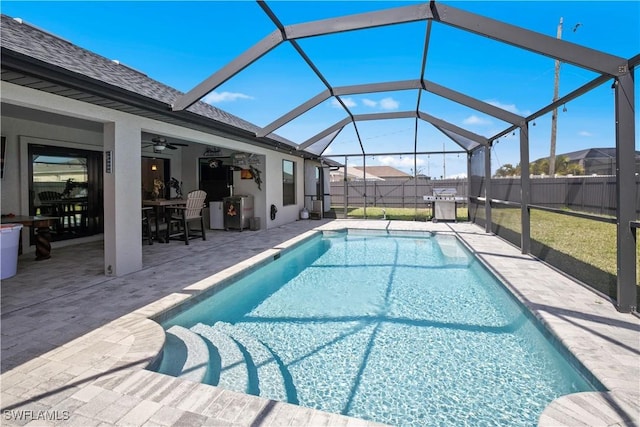 view of pool with a fenced in pool, a ceiling fan, glass enclosure, fence, and a patio area