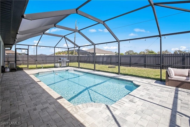 view of pool with glass enclosure, a fenced backyard, area for grilling, a fenced in pool, and a patio area