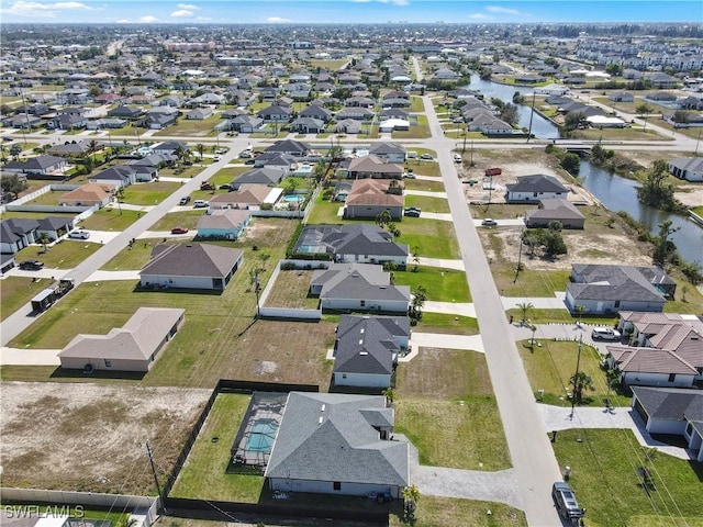 drone / aerial view featuring a water view and a residential view