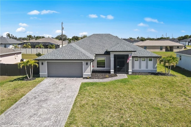 ranch-style home with a garage, fence, and a front lawn