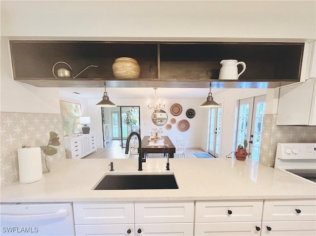 kitchen featuring tasteful backsplash, white cabinets, white dishwasher, a sink, and electric range oven