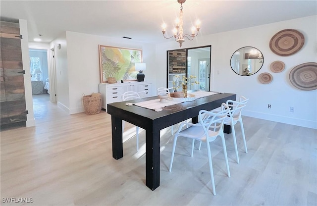 dining space with baseboards, light wood-type flooring, and a notable chandelier