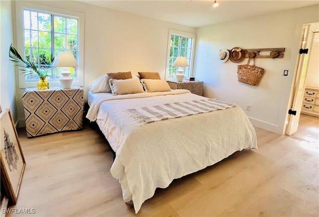 bedroom featuring baseboards and light wood-style floors
