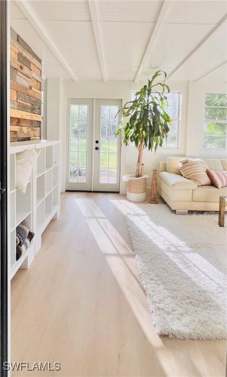 unfurnished sunroom featuring french doors, beam ceiling, and a healthy amount of sunlight