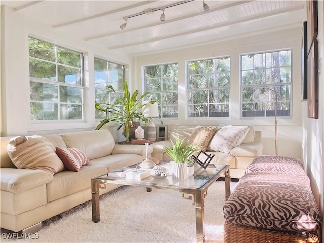 sunroom with beamed ceiling, rail lighting, and a wealth of natural light