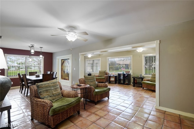 living room featuring light tile patterned floors, ceiling fan, and baseboards