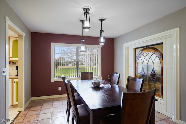 dining space featuring light tile patterned floors and baseboards