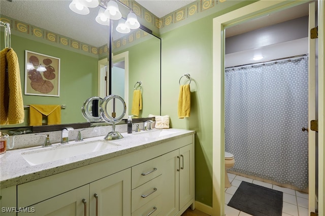 full bath featuring double vanity, a sink, toilet, and tile patterned floors