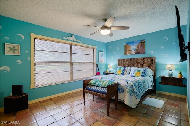 tiled bedroom featuring a textured ceiling, a ceiling fan, and baseboards