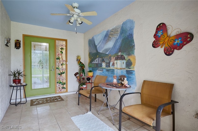 interior space with ceiling fan and a textured wall