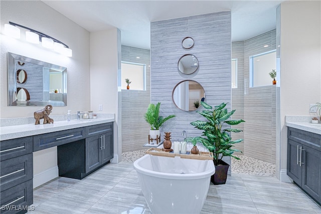 full bath with walk in shower, tile patterned flooring, a freestanding tub, and vanity