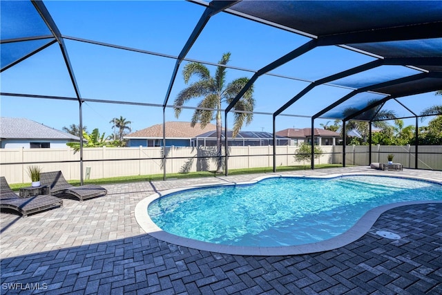 view of swimming pool featuring glass enclosure, a patio area, and a fenced in pool