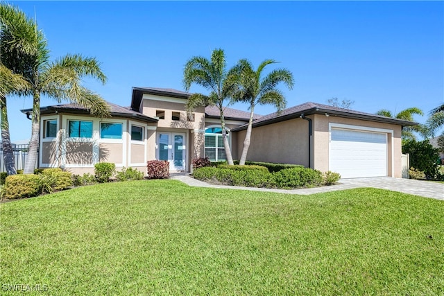 view of front of house with decorative driveway, an attached garage, a front lawn, and stucco siding