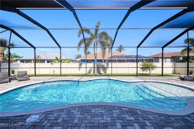 view of pool featuring a lanai, a patio area, a residential view, and a fenced in pool