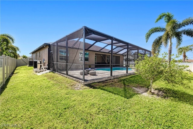 back of house with an outdoor pool, a fenced backyard, a lanai, a yard, and a patio area