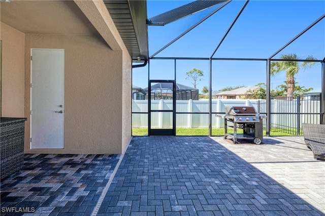 view of patio featuring a lanai, a fenced backyard, and a grill