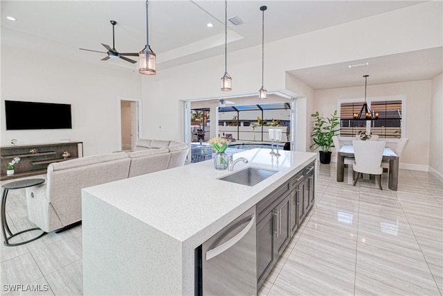 kitchen featuring open floor plan, light countertops, stainless steel dishwasher, and decorative light fixtures