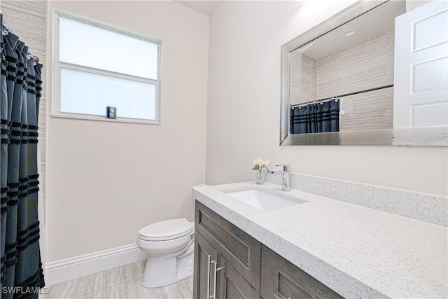 full bathroom featuring a shower with shower curtain, vanity, toilet, and baseboards