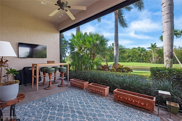 sunroom featuring plenty of natural light and a ceiling fan