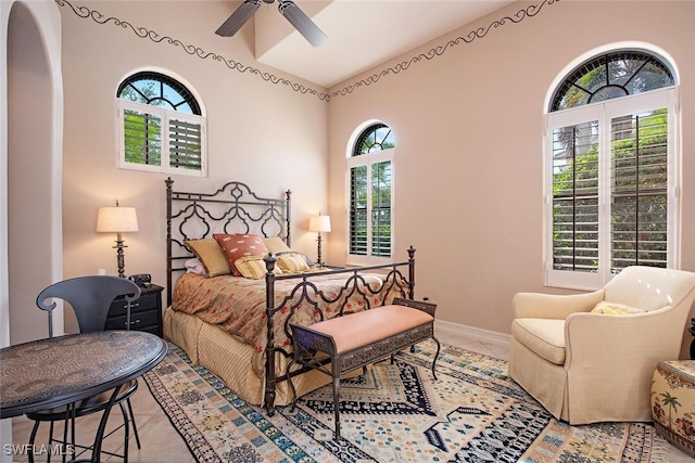 bedroom with lofted ceiling, tile patterned flooring, and baseboards