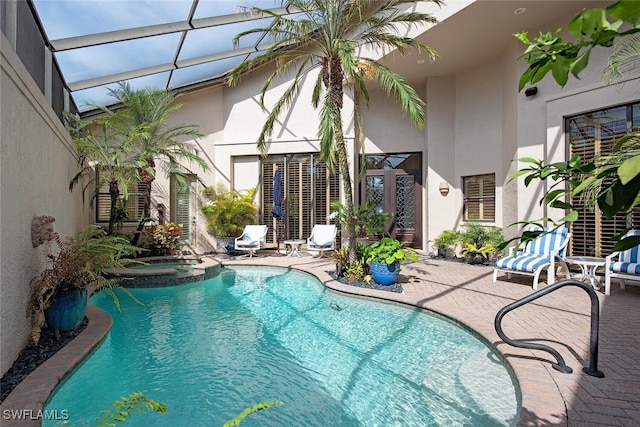 view of pool with a patio area, a lanai, and a pool with connected hot tub