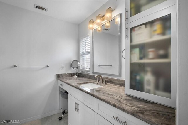 bathroom featuring vanity, visible vents, and baseboards