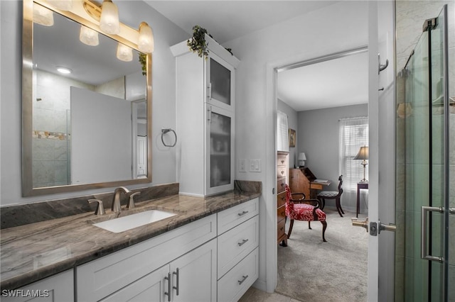 full bathroom with a shower with door and vanity