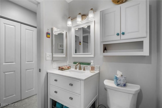 bathroom featuring a closet, vanity, toilet, and tile patterned floors