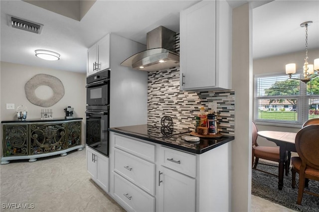 kitchen featuring visible vents, dark countertops, white cabinetry, pendant lighting, and exhaust hood