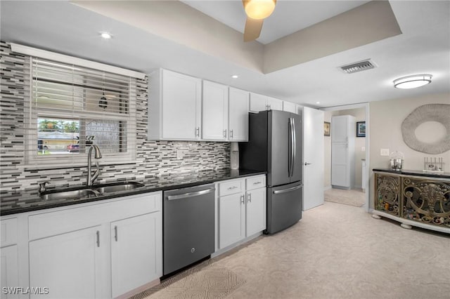 kitchen featuring stainless steel appliances, tasteful backsplash, visible vents, white cabinets, and a sink