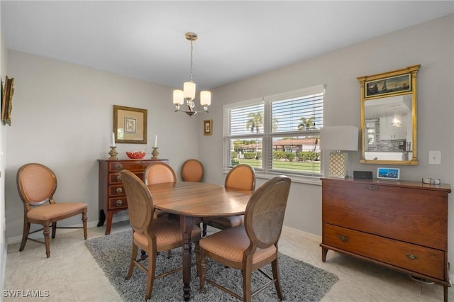 dining room featuring baseboards and a notable chandelier