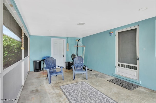 sitting room with visible vents and unfinished concrete flooring