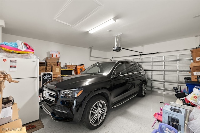 garage featuring a garage door opener and freestanding refrigerator