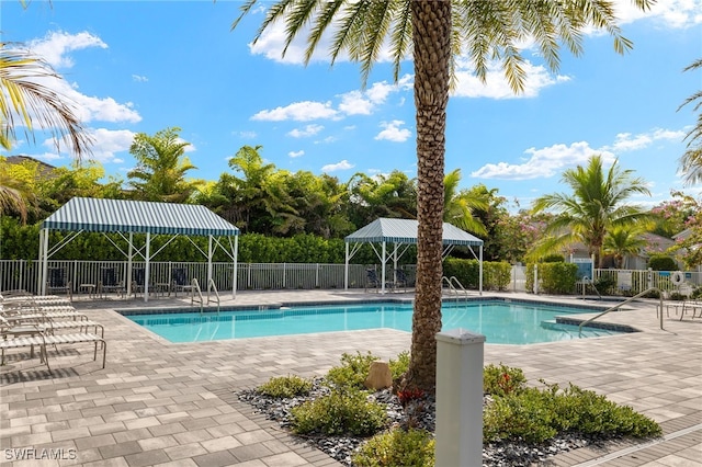 community pool featuring a gazebo, a patio area, and fence