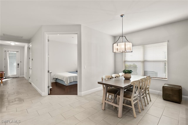 dining area featuring light tile patterned flooring and baseboards