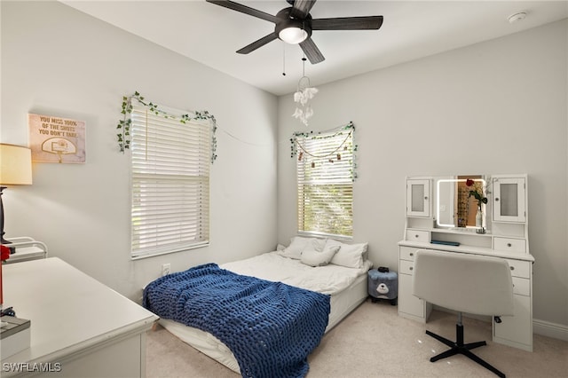 bedroom with a ceiling fan and light colored carpet