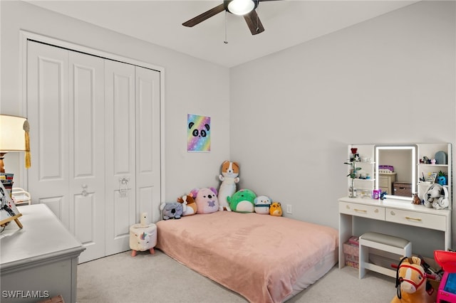 bedroom featuring a closet, light colored carpet, and ceiling fan