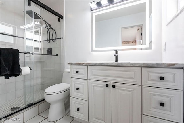 bathroom with tile patterned floors, vanity, toilet, and a shower stall