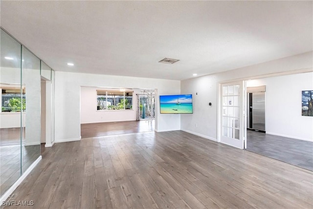 unfurnished living room featuring recessed lighting, visible vents, baseboards, and wood finished floors