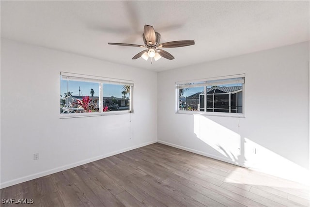 spare room with ceiling fan, baseboards, and wood finished floors