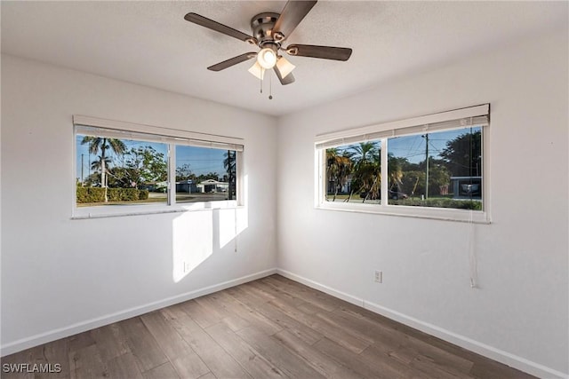 spare room with ceiling fan, baseboards, and wood finished floors