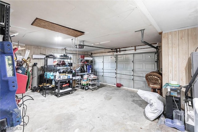 garage with wooden walls and a garage door opener