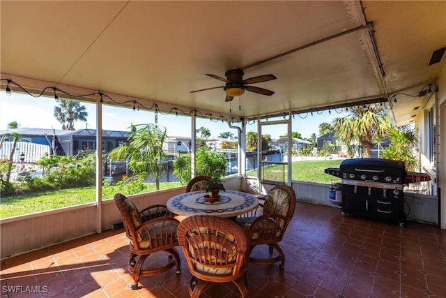 sunroom / solarium with ceiling fan and a residential view