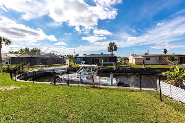 view of dock featuring a residential view, a lawn, and fence