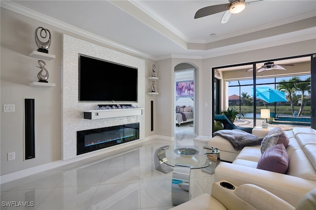 28074 Edenderry Ct, Bonita Springs, FL 34135 - living room featuring a ceiling fan, crown molding, baseboards, and a glass covered fireplace