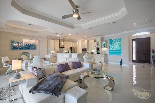 28074 Edenderry Ct, Bonita Springs, FL 34135 - living room featuring a raised ceiling, crown molding, a ceiling fan, baseboards, and a chandelier