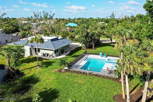 view of pool with a pool with connected hot tub, a patio area, a lawn, and a fenced backyard