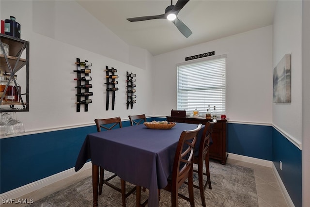 dining area with tile patterned flooring, a ceiling fan, and baseboards