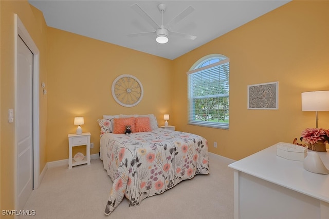 bedroom with light carpet, ceiling fan, and baseboards