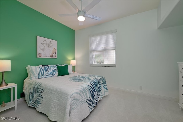 bedroom with light carpet, ceiling fan, and baseboards